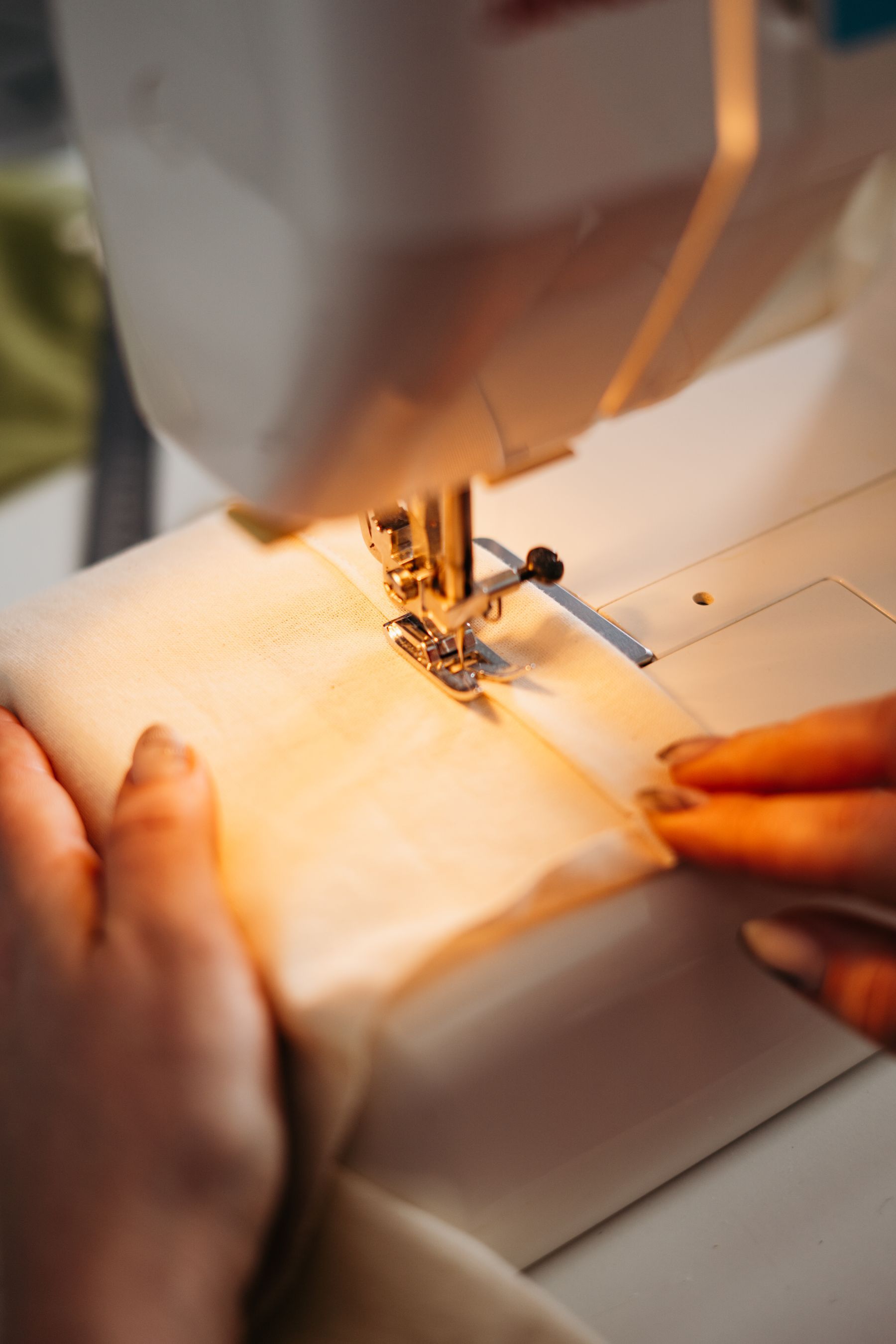 Manos guiando una tela en una máquina de coser