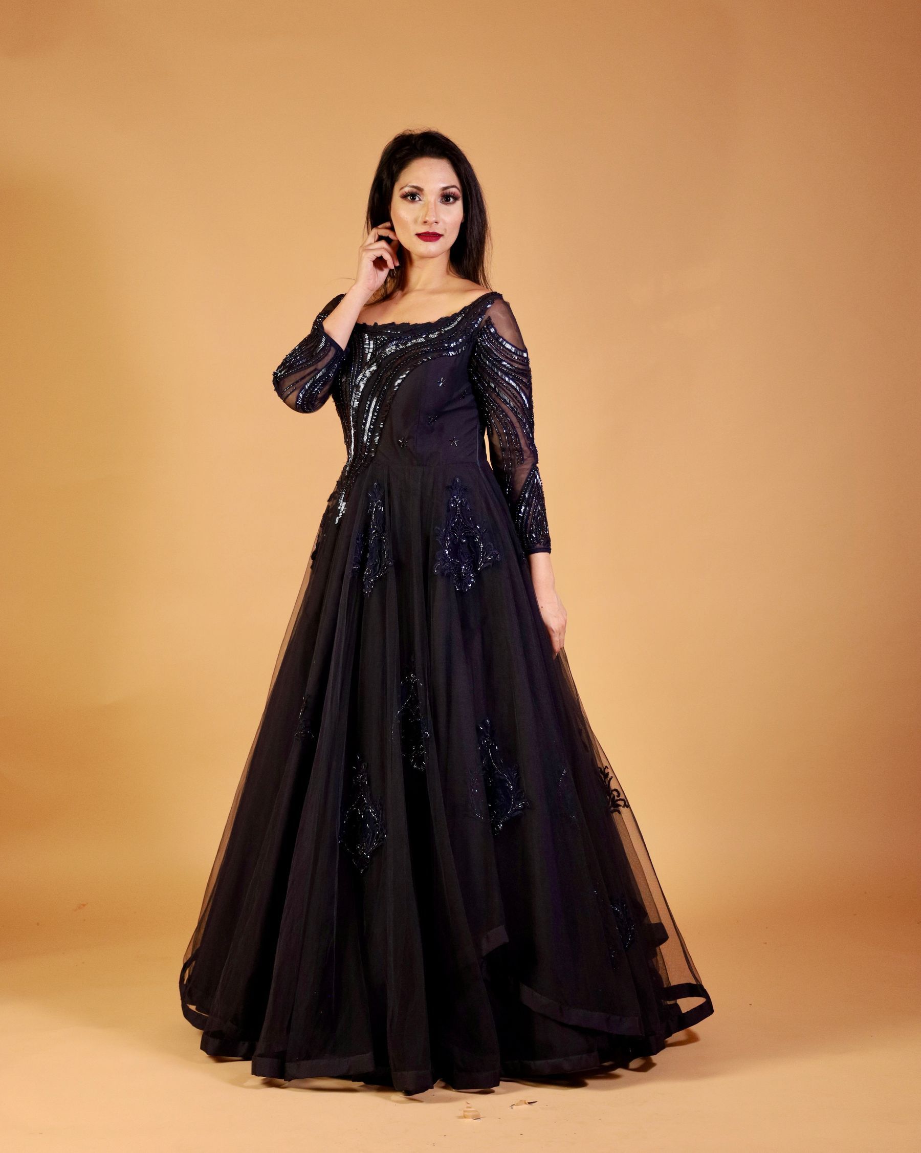 Vestido largo de gala negro sobre fondo cálido